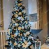 Umělý vánoční stromek Jedle Kavkazská 220cm je hustě zdobený bílými ozdobami.