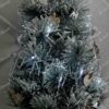 Umělý vánoční stromek Mini Borovice Zasněžená 60cm je zdoben dřevěnými ozdobami.