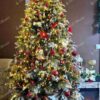 Umělý vánoční stromek 3D Jedle Zasněžená 180cm je hustě vyzdoben zlatými a červenými ornamenty.