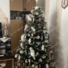 Umělý vánoční stromek 3D Jedle Zasněžená 180cm je hustě zdobený bílými a růžovými ozdobami a sovičkami.