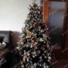 Umělý vánoční stromek 3D Jedle Zasněžená 180cm je moderně zdoben zlatými a měděnými ozdobami.