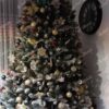 Umělý vánoční stromek Smrk Křišťálový 250cm je hustě vyzdoben různými vánočními ozdobami.