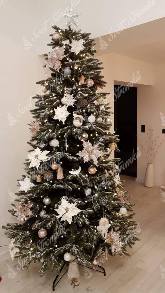 Zasněžený vánoční stromek 3D ozdobený bílými květy a zlatými koulemi.