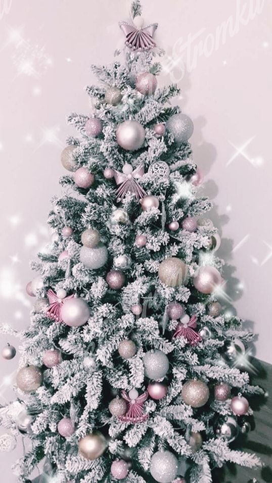Bílý vánoční stromek zdobený stříbrnými a růžovými koulemi.