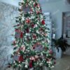 Umělý vánoční stromek 3D Smrk Exkluzivní 240cm je vkusně vyzdoben bílými a červenými ozdobami, plyšovými hračkami a vánočními obálkami.