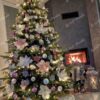 Umělý vánoční stromek 3D Smrk Skandinávský 210cm je vkusně vyzdoben bílými, stříbrnými a růžovými ozdobami a vánočními růžemi.