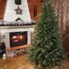 Dokonalý hustý vánoční stromek ve Vánoční ozdobené místnosti s krbem.