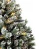 Detailní fotka zasněžených větviček umělého vánočního stromku.