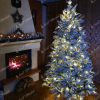 Vánoční stromek s LED osvětlením ve vánočně vyzdobené místnosti. Stromek je sněhově bílé barvy bez ozdob.
