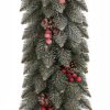 Detail tyrkysově zelené vánoční girlandy doplněné o borové šišky a červené lesní plody.