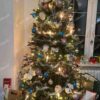 Umělý vánoční stromek 3D Smrk Úzký 180cm je vyzdoben bílými, modrými a fialovými ozdobami.