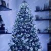 Umělý vánoční stromek 3D Jedle Kavkazská XL 210cm je hustě vyzdoben bílými a stříbrnými ozdobami.