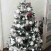 Umělý vánoční stromek Smrk Stříbrný 180cm je ozdoben bílými a stříbrnými ozdobami