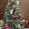 Umělý vánoční stromek se zasněženými konci větviček, ozdobený šiškami a lesními plody, s červenými ozdobami, v obývák