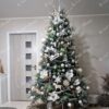 Umělý vánoční stromeček s ledově zelenými hustými větvičkami, ozdobený bílo-zlatými ozdobami, v obýváku