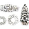 Zasněžené ozdobené vánoční dekorace stříbrno-bíla, jsou zdobeny stříbrnými a bílými ozdobami.