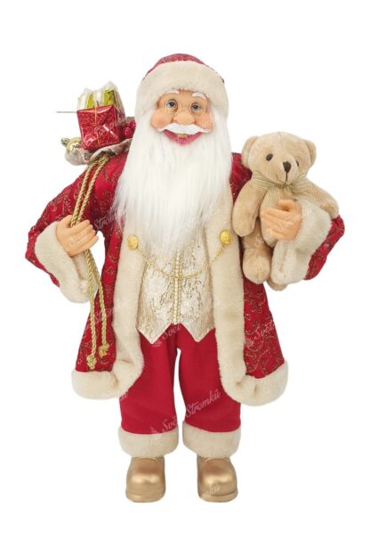 Vánoční dekorace Santa Claus červeno-zlatý 60cm Na sobě má červený kabátek se zlatým vzorem a zlatými řetízky a pod ním zlatou vestu. Na nohou má zlaté boty a v ruce drží plyšovou hračku. Má husté dlouhé bílé vousy a brýle.